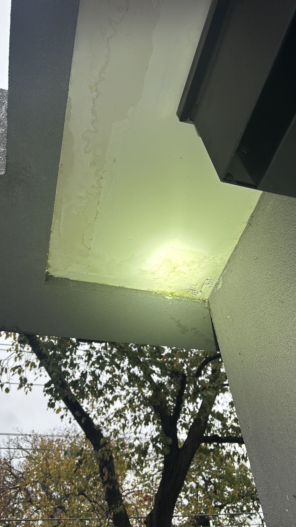 Moisture staining under a balcony where the drainage connection is leaking, found during a defect investigation in Maidstone
