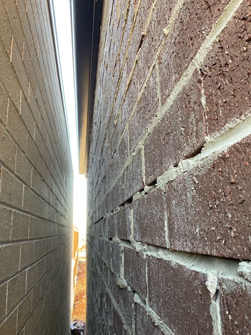Voids and holes left in the brick mortar joints, found during a pre-handover inspection in Aintree